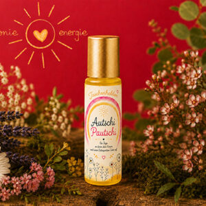 Aroma-Roll-on Autschi Pautschi aus der Serie Taschenhelden von Harmonie Energie, umgeben von getrockneten Kraeutern und Blueten